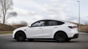 Model Y Juniper seitlich auf trockener Fahrbahn, Crashtest-Hinweis nur als Motiv, kein Flammenbild
